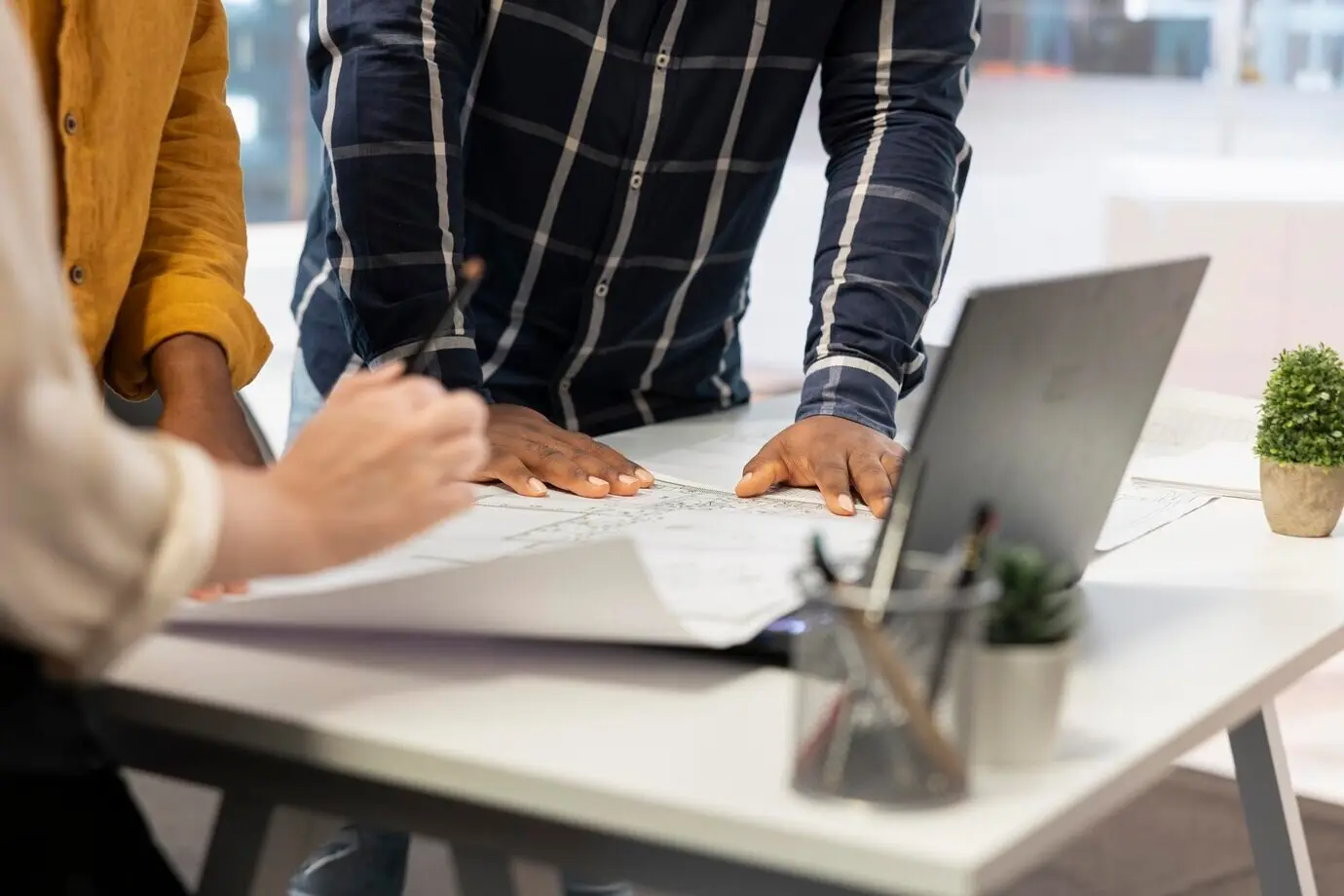 Предприниматель и агенты по недвижимости совместно работают над планированием корпоративного офиса.